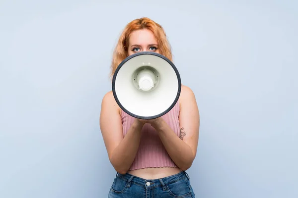 Jovem Mulher Sobre Fundo Azul Isolado Gritando Através Megafone — Fotografia de Stock