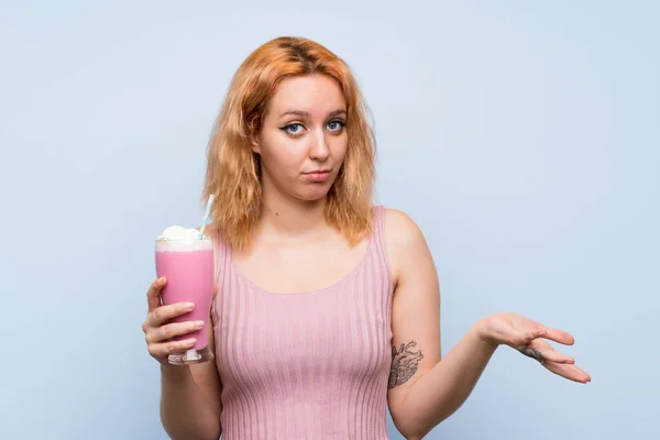 Jovem Com Batido Morango Sobre Fundo Azul Isolado Fazendo Gestos — Fotografia de Stock