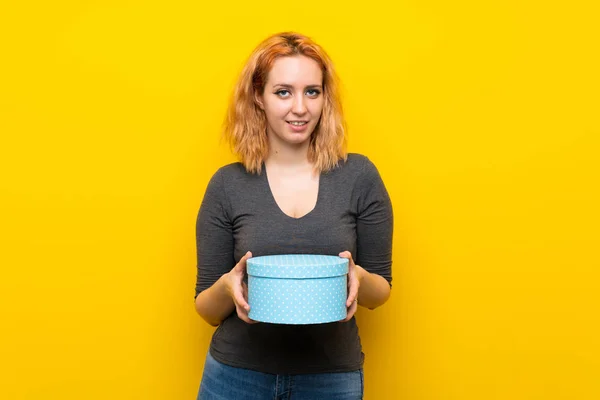 Jonge Vrouw Geïsoleerde Gele Achtergrond Holding Gift Box — Stockfoto