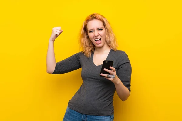 Cep Telefonu Kullanarak Izole Sarı Arka Plan Üzerinde Genç Kadın — Stok fotoğraf