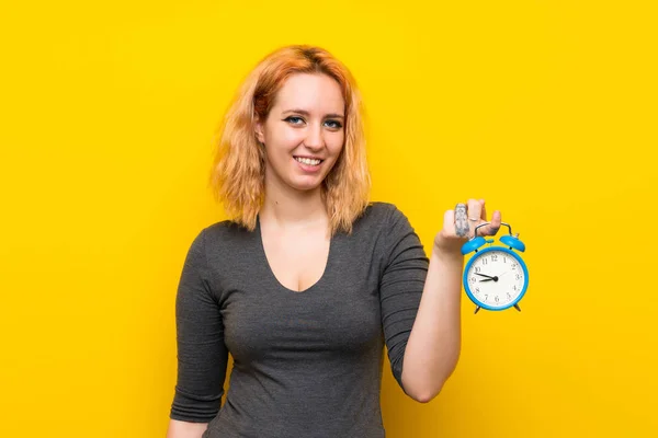 Mujer Joven Sobre Fondo Amarillo Aislado Sosteniendo Reloj Despertador Vintage — Foto de Stock