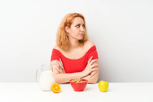 Young woman having breakfast thinking an idea