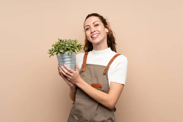 Jardinero mujer sosteniendo una planta — Foto de Stock