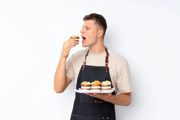 Junger Gutaussehender Mann Über Isoliertem Weißem Hintergrund Hält Mini Kuchen — Stockfoto