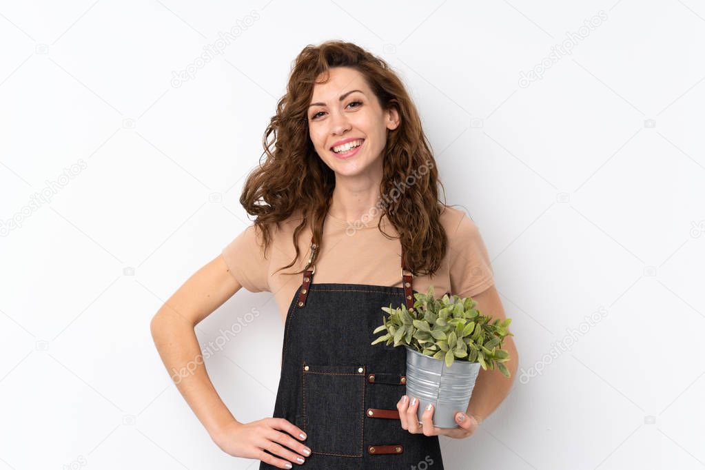 Young pretty woman over isolated background taking a flowerpot