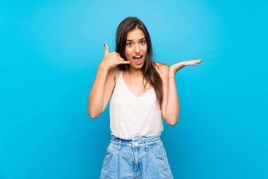 Soyutlanmış mavi arka planda genç bir kadın telefon hareketlerinde ve şüphelerde bulunuyor