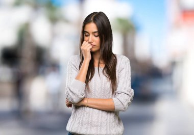 Açık havada kuşkuları olan esmer bir kadın.