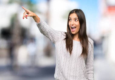 Genç İspanyol esmer kadın dışarıyı işaret ediyor.