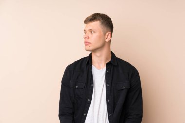 Genç yakışıklı adam yan bakıyor.