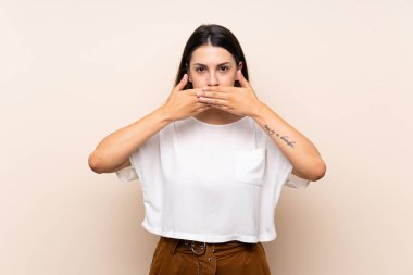 Elleri ile ağız kapsayan izole arka plan üzerinde genç esmer kadın