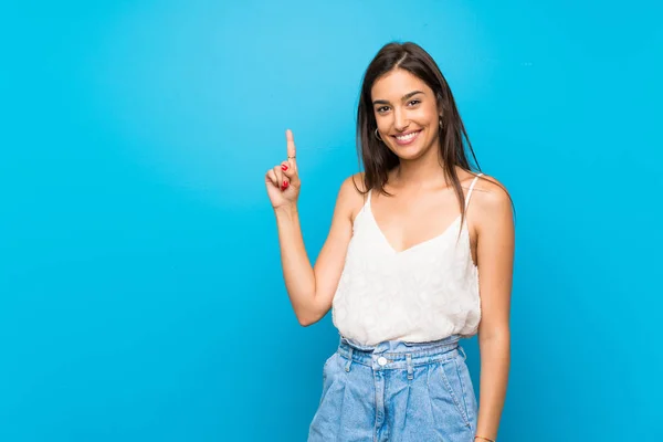 Giovane Donna Sfondo Blu Isolato Che Mostra Solleva Dito Nel — Foto Stock