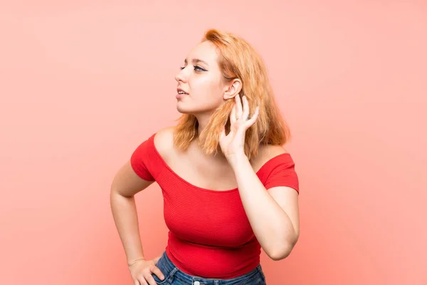 Mujer Joven Sobre Fondo Rosa Aislado Escuchando Algo Poniendo Mano — Foto de Stock
