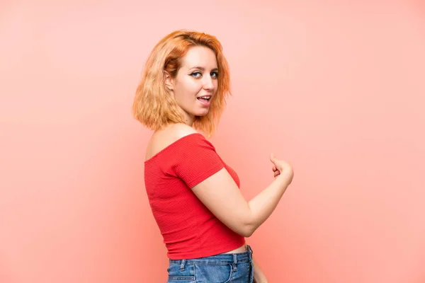 Jonge Vrouw Geïsoleerde Roze Achtergrond Wijzen Terug — Stockfoto