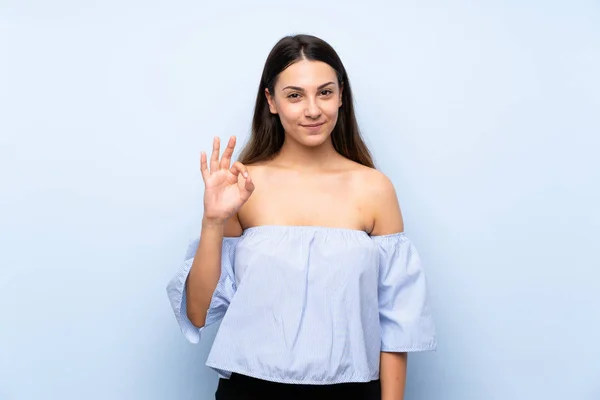 Jovem Morena Sobre Fundo Azul Isolado Mostrando Sinal Com Dedos — Fotografia de Stock