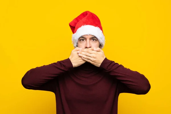Человек Рождественской Шляпе Изолированном Желтом Фоне Закрывает Рот Руками — стоковое фото