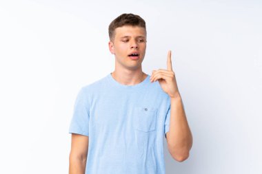 Soyutlanmış beyaz arka planda genç yakışıklı bir adam bir fikir düşünüyor.