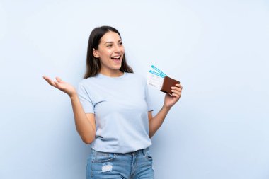 İzole edilmiş mavi duvarın üzerinden yüzleri sürpriz bir ifadeyle geçen yolcu kadın.