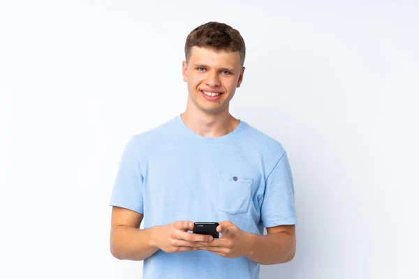 Fiatal Jóképű Férfi Elszigetelt Fehér Háttér Küld Egy Üzenetet Mobil — Stock Fotó