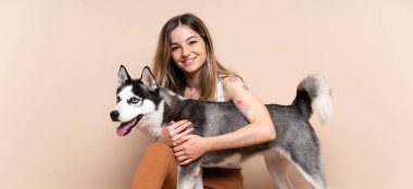 Genç ve güzel bir kadın. İri köpeğiyle içeride yerde oturuyor.