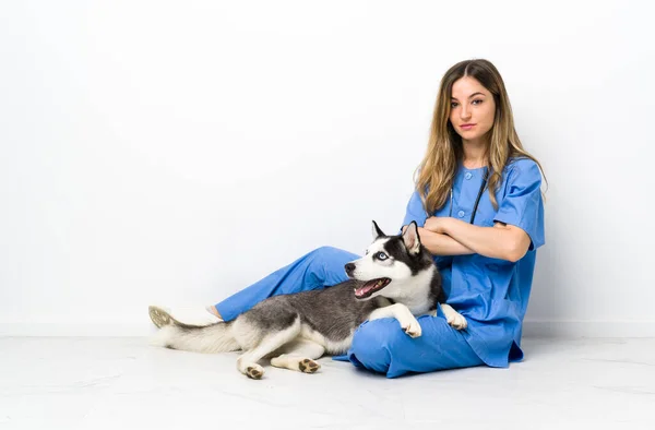 Sibiryalı Husky Köpeği Olan Veteriner Doktor Yerde Oturup Kollarını Kavuşturuyor — Stok fotoğraf