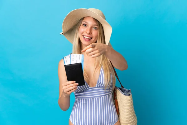 Jonge Blonde Vrouw Met Een Paspoort Geïsoleerd Blauwe Achtergrond Wijst — Stockfoto