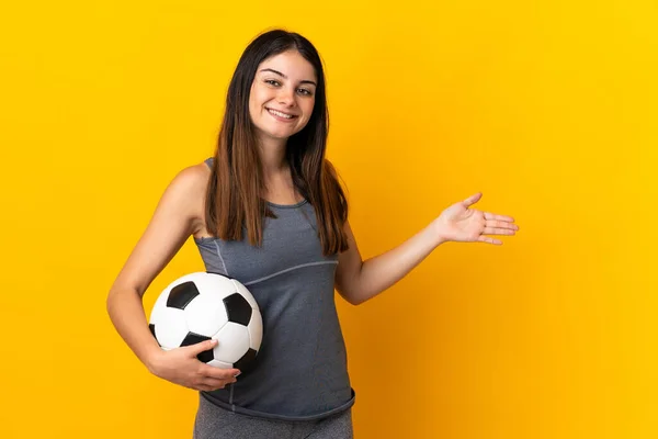 Junge Fußballerin Isoliert Auf Gelbem Hintergrund Die Hände Zur Seite — Stockfoto