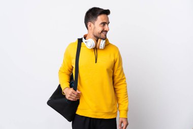 Spor çantalı genç adam beyaz arka planda izole edilmiş.