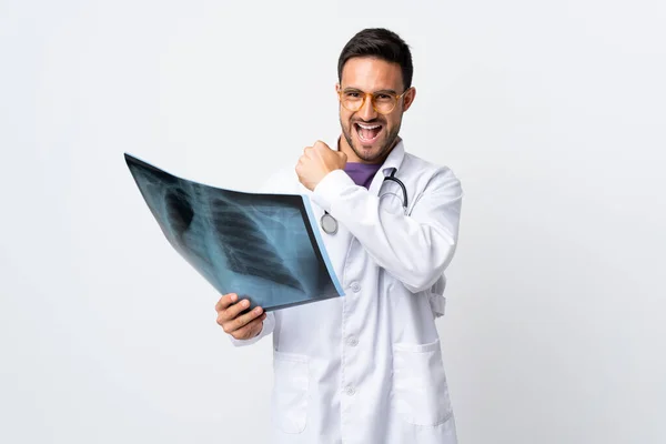 Młody Lekarz Trzyma Radiografię Odizolowaną Białym Tle Świętując Zwycięstwo — Zdjęcie stockowe