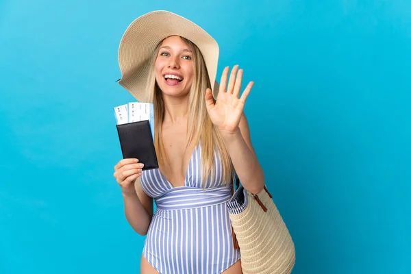 Jovem Loira Segurando Passaporte Isolado Fundo Azul Saudando Com Mão — Fotografia de Stock