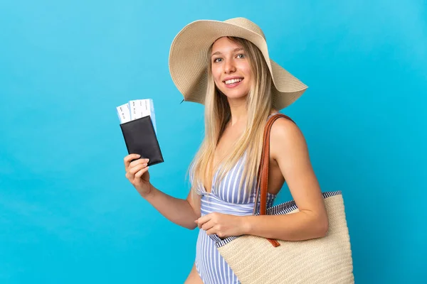 Jonge Blonde Vrouw Met Een Paspoort Geïsoleerd Blauwe Achtergrond Glimlachen — Stockfoto