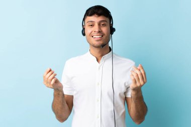 Kolombiyalı tele-pazarlamacı, izole bir geçmişi olan, para hareketi yapan bir kulaklıkla çalışıyor.