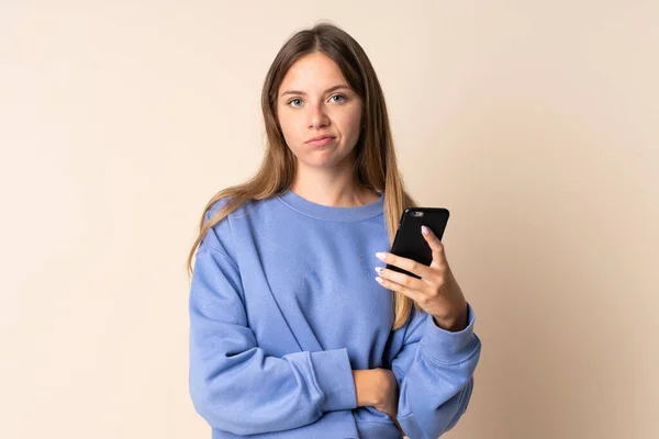 Νεαρή Λιθουανή Γυναίκα Που Χρησιμοποιεί Κινητό Τηλέφωνο Απομονωμένο Μπεζ Φόντο — Φωτογραφία Αρχείου