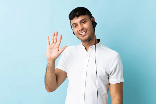 Telemarketer Kolumbijský Muž Pracující Sluchátky Přes Izolované Pozadí Salutování Rukou — Stock fotografie