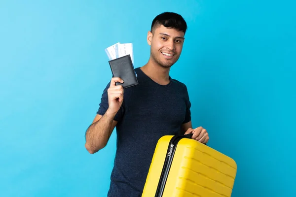 Jovem Colombiano Isolado Fundo Azul Férias Com Mala Passaporte — Fotografia de Stock