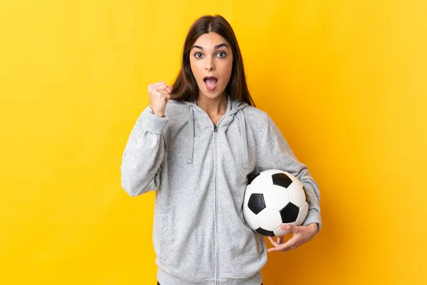 Młoda Piłkarka Kobieta Odizolowana Żółtym Tle Świętując Zwycięstwo Pozycji Zwycięzcy — Zdjęcie stockowe