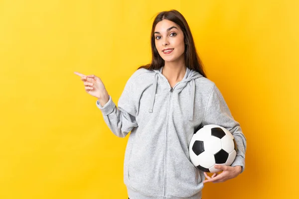 Młoda Piłkarz Kobieta Odizolowany Żółtym Tle Wskazując Palcem Bok — Zdjęcie stockowe