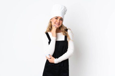 Genç Brezilyalı aşçı kadın beyaz arka planda izole edilmiş gülümserken yukarı bakıyor