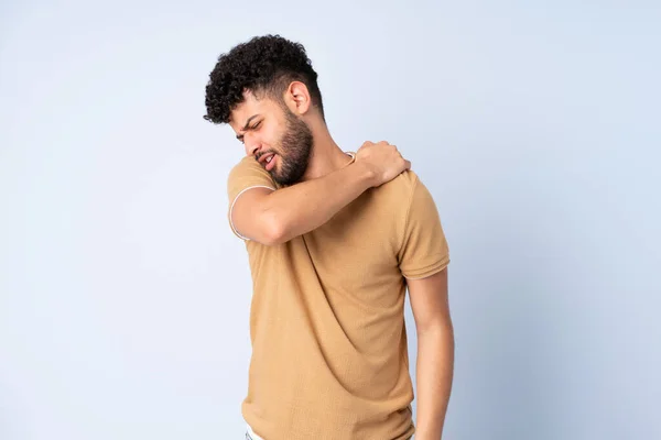 Young Moroccan man isolated on blue background suffering from pain in shoulder for having made an effort