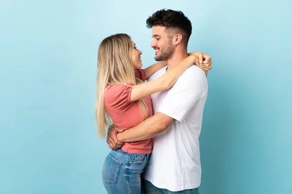 Jovem Casal Caucasiano Isolado Fundo Azul Abraço — Fotografia de Stock