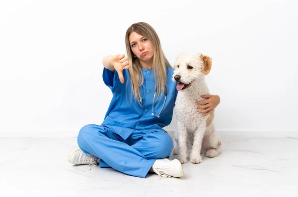 Молодая Ветеринар Собакой Сидящей Полу Показывает Большой Палец Вниз Негативным — стоковое фото