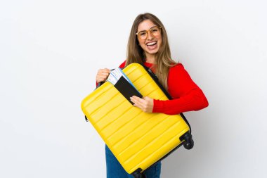 İzole edilmiş beyaz bir geçmişi olan genç bir kadın, valizi ve pasaportuyla tatilde.