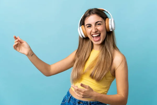 Mujer Joven Sobre Fondo Azul Aislado Escuchando Música Haciendo Gesto —  Fotos de Stock