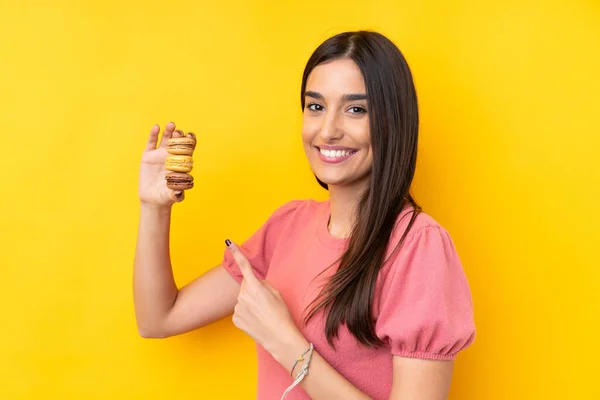 Giovane Donna Bruna Sfondo Giallo Isolato Tenendo Macaron Francesi Colorati — Foto Stock