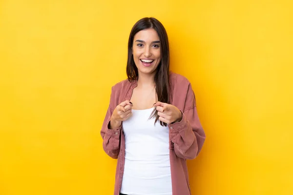 Joven Morena Sobre Aislado Fondo Amarillo Apuntando Hacia Frente Sonriendo —  Fotos de Stock