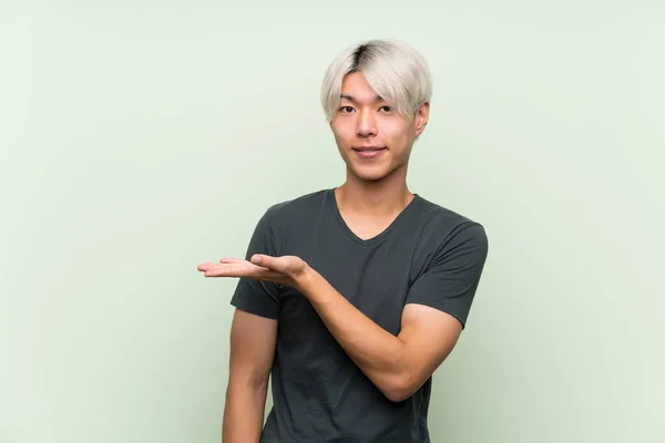 Junger Asiatischer Mann Über Isoliertem Grünen Hintergrund Präsentiert Eine Idee — Stockfoto