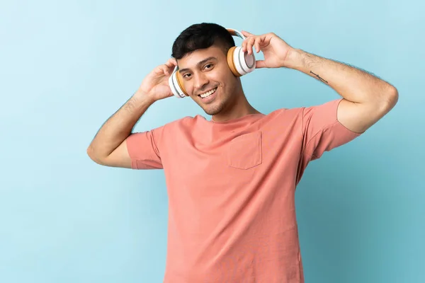 Jonge Colombiaanse Man Geïsoleerd Blauwe Achtergrond Luisteren Muziek — Stockfoto