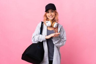 Spor çantalı genç bir bayan izole arka planda alkışlıyor.