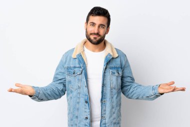 Beyaz arka planda sakallı, yakışıklı genç bir adamın şüpheleri var.