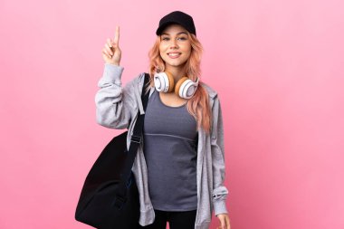 Spor çantasıyla izole edilmiş arka planı olan genç bir kadın harika bir fikre işaret ediyor.