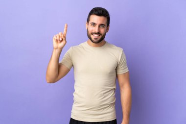 Sakallı ve soyutlanmış genç yakışıklı adam harika bir fikre işaret ediyor.